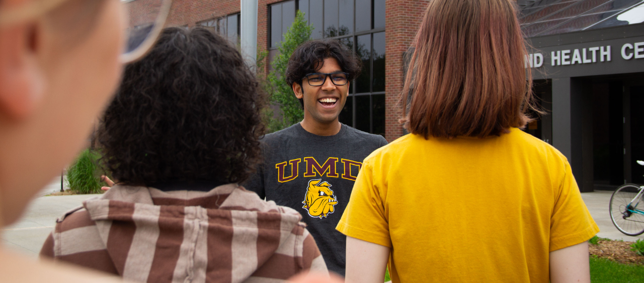 Bulldgog Tour Guide leads group of students on UMD campus